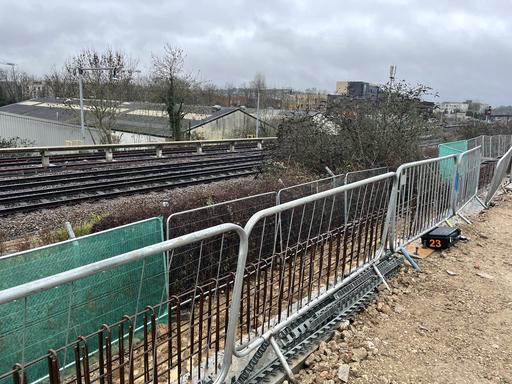 A vibration monitor positioned on a construction site adjacent to a railway line.
